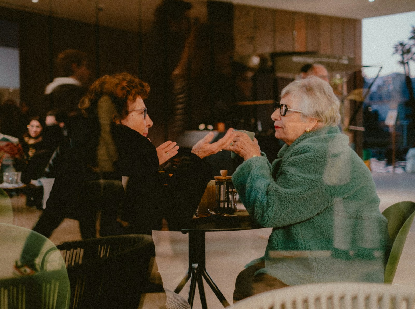 Female insurance agent meeting with an older couple in a Tucson diner, discussing Medicare insurance options